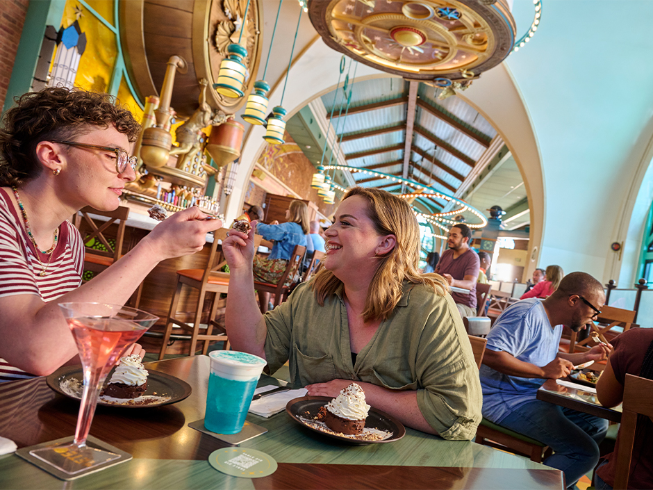 Two guests dining in Meteor Astropub in Celestial Park at Epic Universe