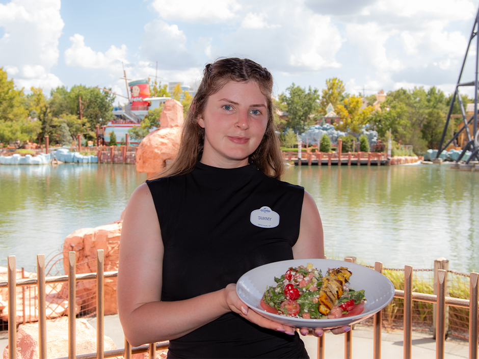 USF Snack Carts Manager Tammy Crowe holding a plate of her new signature dish, the Watermelon Salad, at Mythos Restaurant in Universal Islands of Adventure.