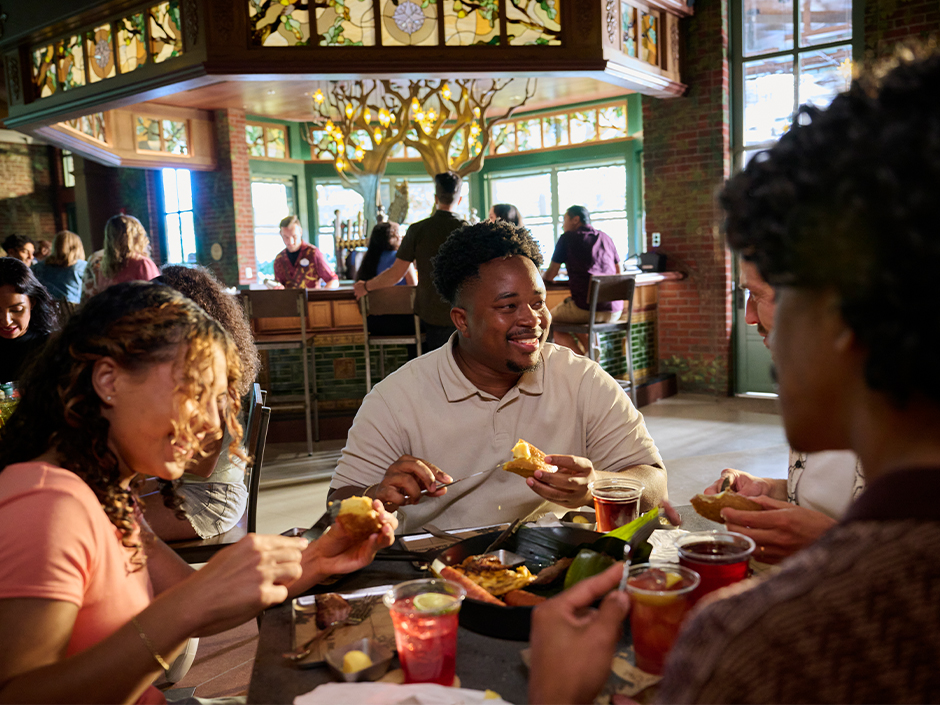 A group of friends dining in The Oak & Star Tavern in Celestial Park at Epic Universe