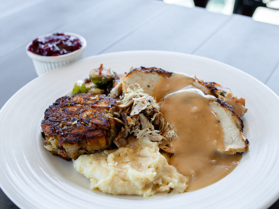A plate of roasted turkey, stuffing, gravy, Brussels sprouts, smashed potatoes, and cranberry sauce at Lombard's Seafood Grille for Thanksgiving at Universal Studios Florida.